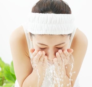 水で洗顔している女性